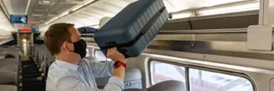 Person placing luggage in overhead bin